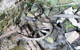 Куча обломков в одном из погребов. видны обломки колеса от телеги.